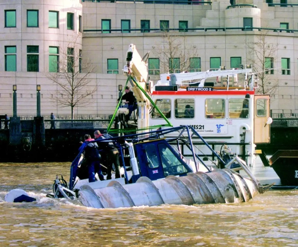 The disabled Snowbird 6 is assisted to shore behind Britains spy headquarters.