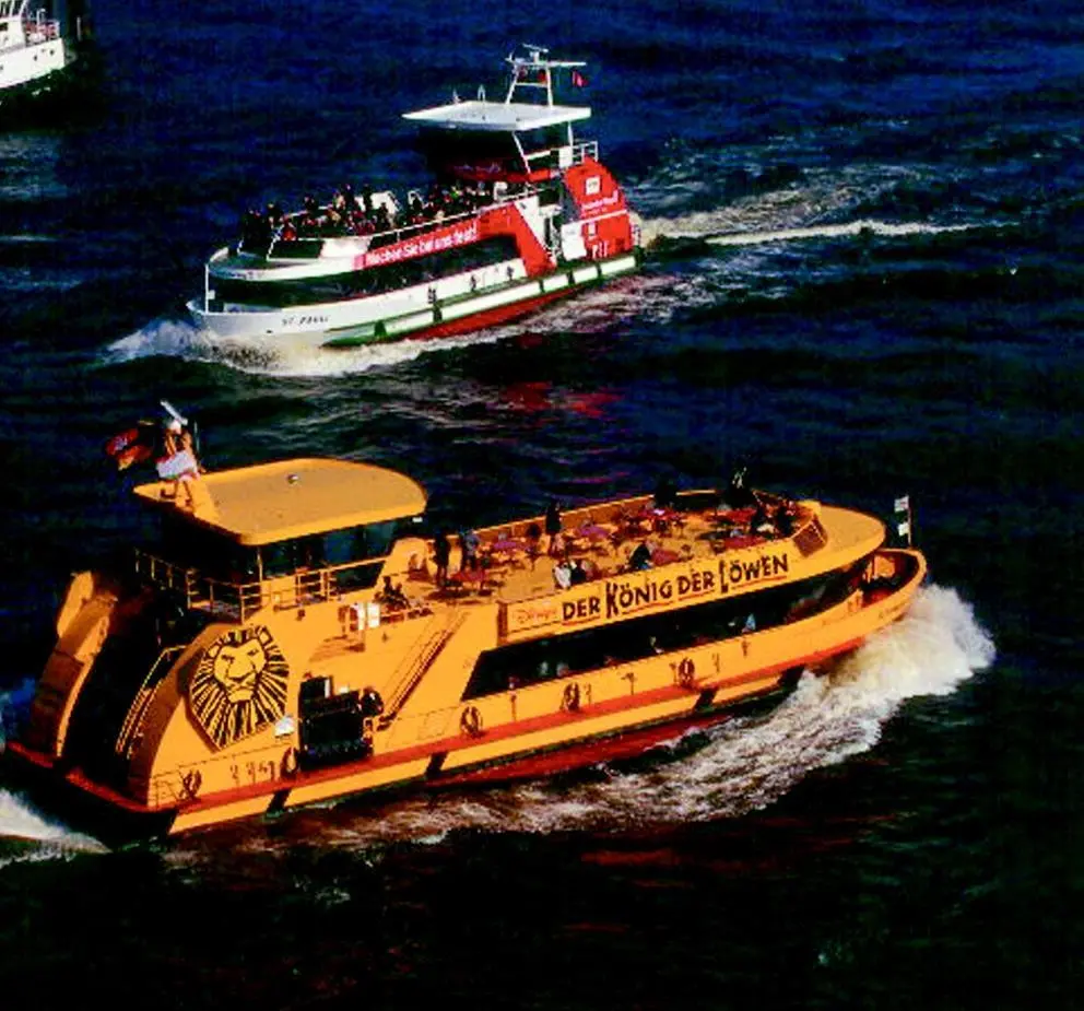 Two of the Z-drive HADAG ferries pass on the busy Hamburg waterfront.