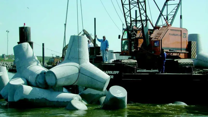 Tetrapods are lowered into place by one of Per Aarsleffs cranes.