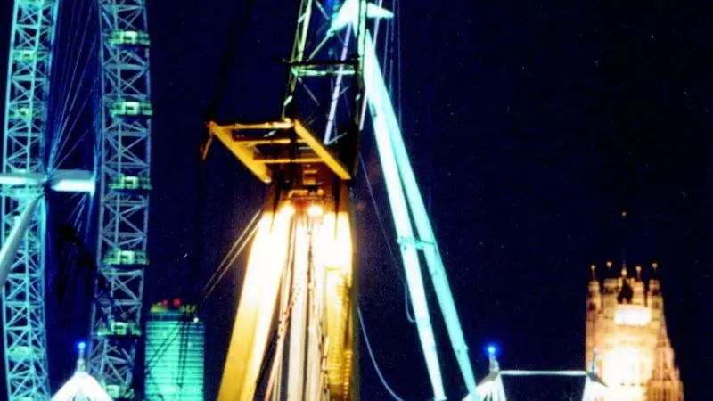 Taklift 3 is seen installing the A-frame pylon at Hungerford Bridge, with the London Eye and the Houses of Parliament in the background.