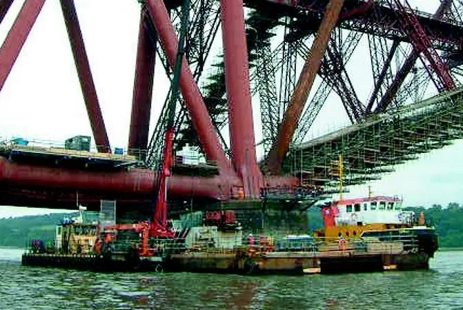 MarineCos tug MarineCo Akela and a barge are seen working on the refurbishment of Scotlands Forth rail Bridge this summer.