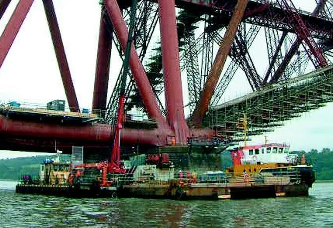 MarineCos tug MarineCo Akela and a barge are seen working on the refurbishment of Scotlands Forth rail Bridge this summer.