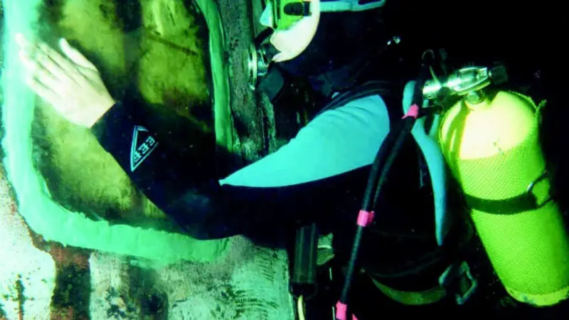 A UMC diver applies protective coating to an exterior weld on the Fujairah side plate insert.