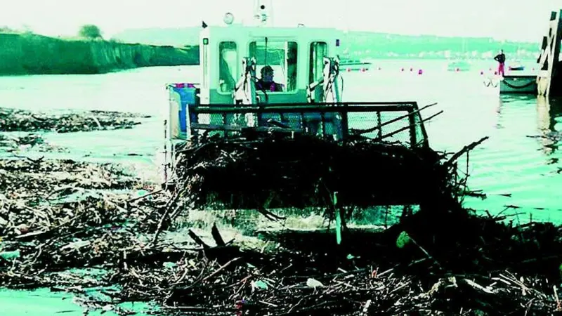 One of the 69 earlier Water Witches is seen removing debris from Cardiff Bay UK.
