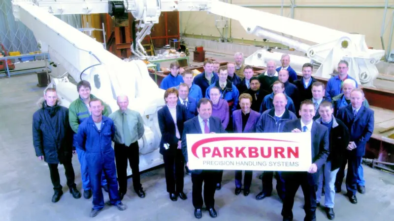 P-PHS employees display the new corporate livery in front of an A-Frame shipborne launch and recovery system awaiting delivery.