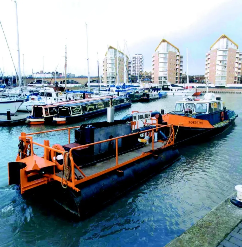The launch Roerdomp with the Water Injection Dredger Baldur at Limehouse Basin, London.