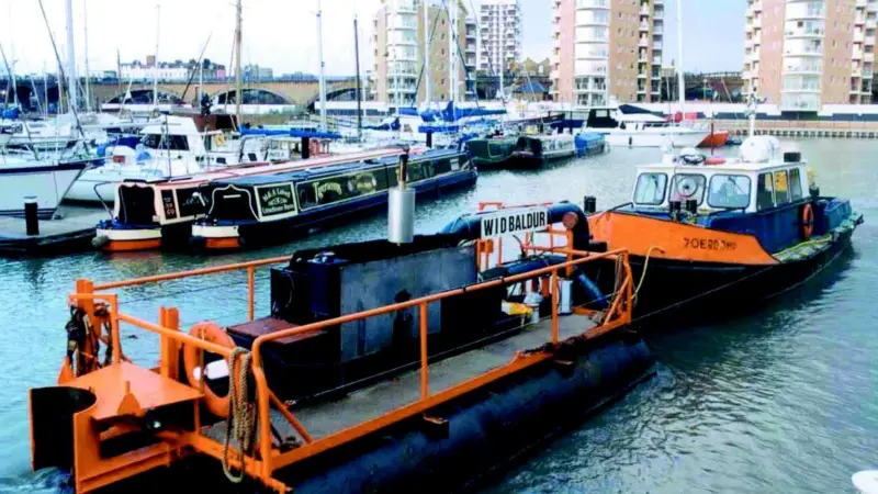 The launch Roerdomp with the Water Injection Dredger Baldur at Limehouse Basin, London.