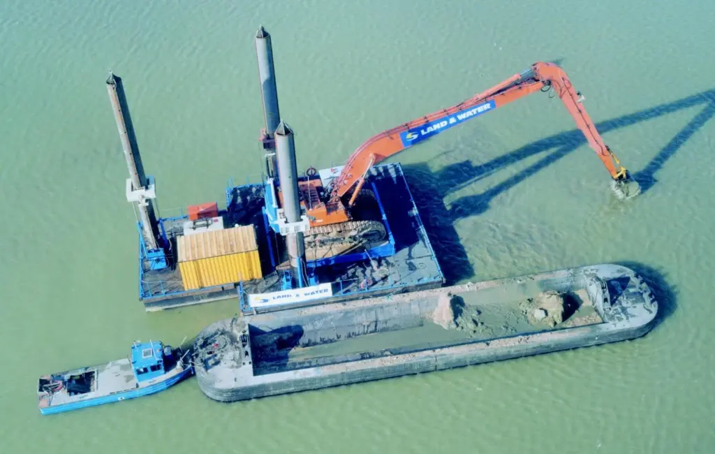 Land & Waters jack-up mounted long reach excavator loads a split barge at Caversham.