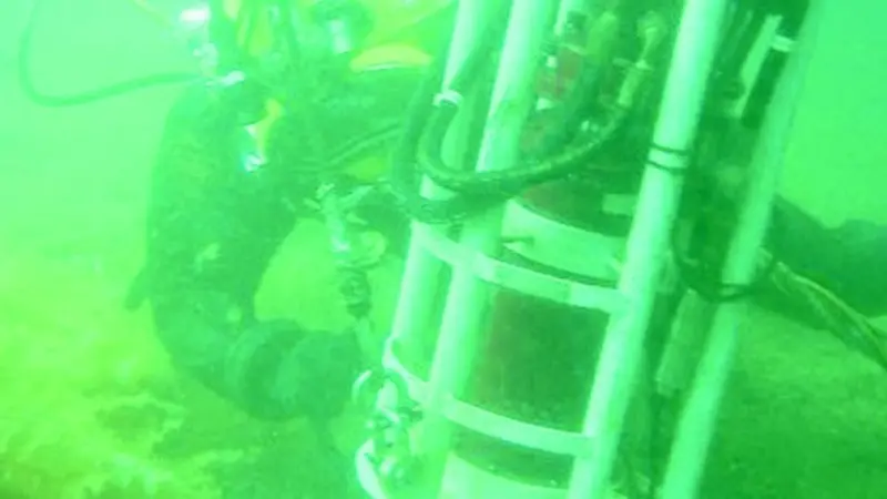 A diver is seen hot tapping for oil on the hull of the Royal Oak.