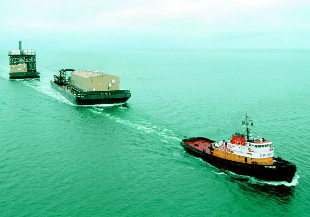 The Crowley tug Bulwark is seen underway with a tandem tow - typical employment for an Invader class vessel.