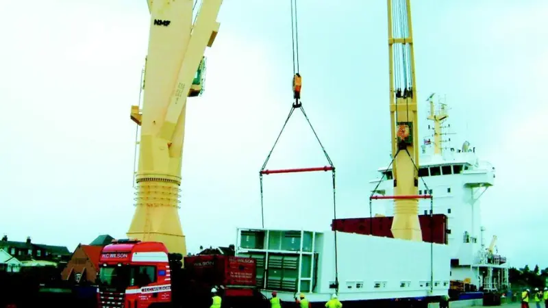 The valuable cargo is transferred from ship to road transport using a Modular Lifting Beam.