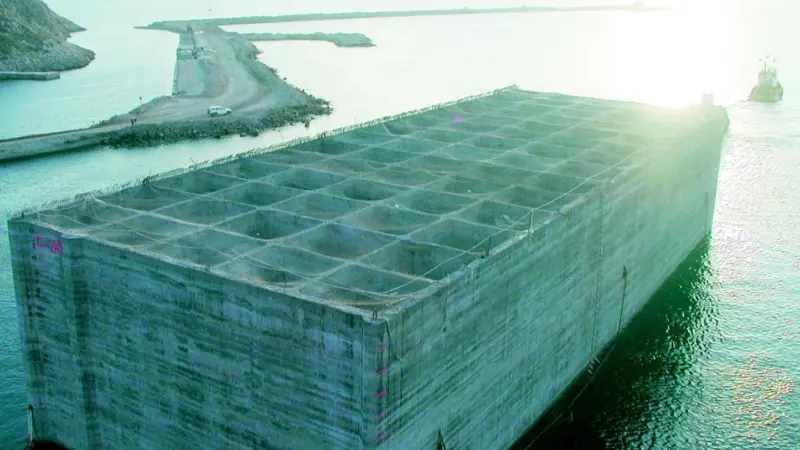 Above left: A tug tows one of the huge concrete blocks to its destination.