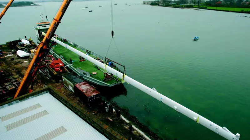 The Mirabella V mast is loaded onto a barge at VT Halmatics Portchester shipyard.