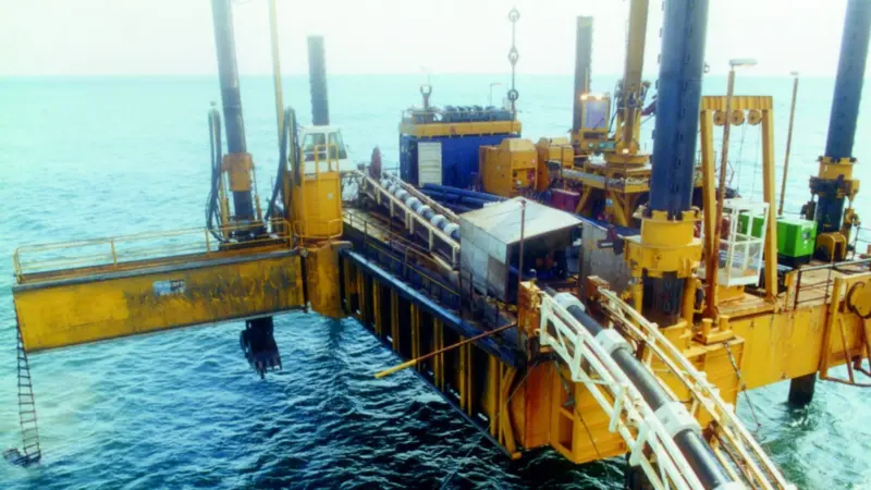 The pipeline is guided into the trench dug by the pontoons integral grab.