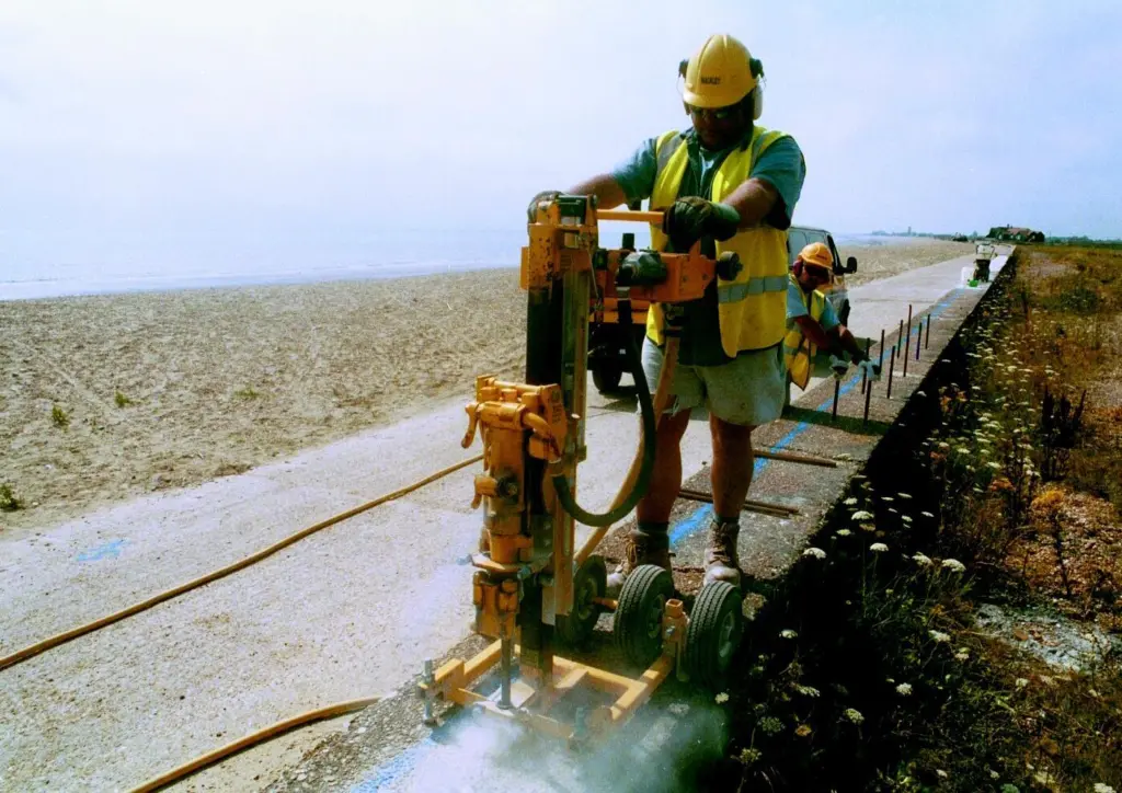 Drilling holes for dowel bars which will form a key for new concrete that will raise existing sea defences along the Kent coast.