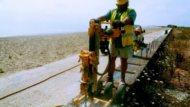 Drilling holes for dowel bars which will form a key for new concrete that will raise existing sea defences along the Kent coast.