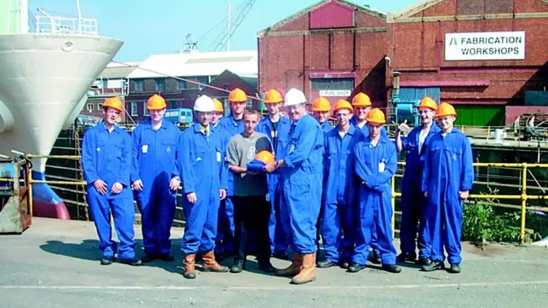 A&P Falmouths managing director Peter Child presents the new apprentices with their personal protective equipment, assisted by training and personnel officer Paul Kneebone.