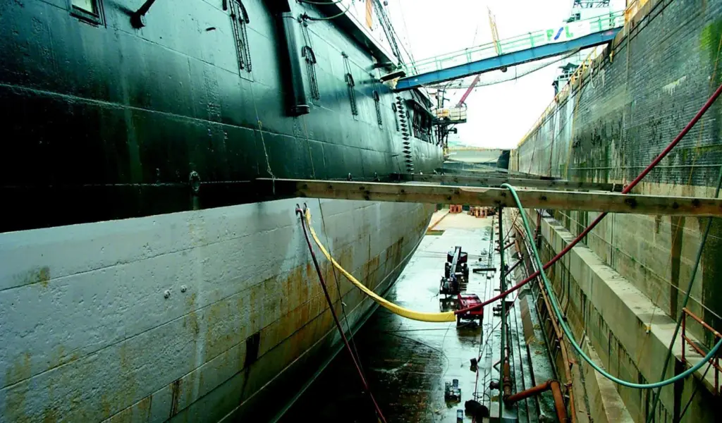 A technician takes thickness measurements along the hull of HMS Warrior. Photo by John Newberry, Warrior Preservation Trust.