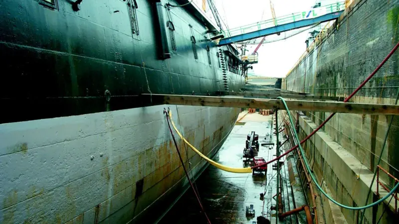 A technician takes thickness measurements along the hull of HMS Warrior. Photo by John Newberry, Warrior Preservation Trust.