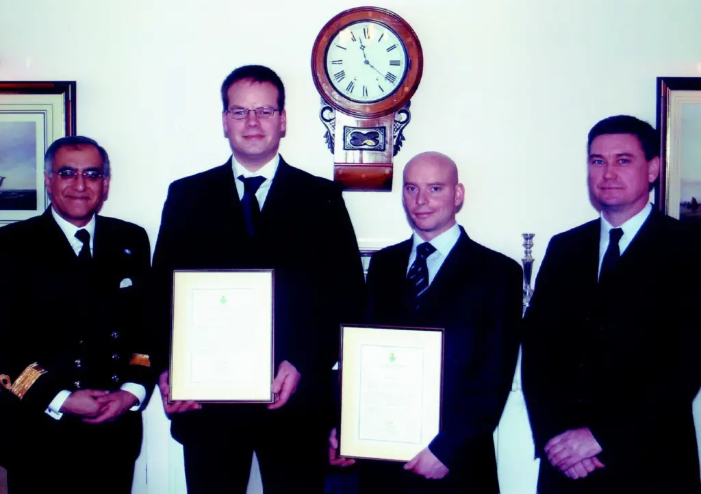 Commodore Amjad Hussain presents bravery awards to UMC diving supervisors Dave Thatcher and James Jee, with UMC director Peter Stevenson in attendance.