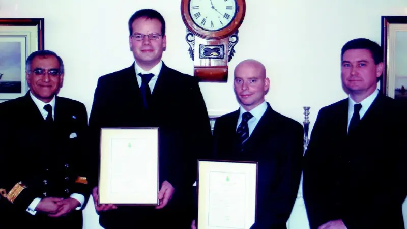 Commodore Amjad Hussain presents bravery awards to UMC diving supervisors Dave Thatcher and James Jee, with UMC director Peter Stevenson in attendance.