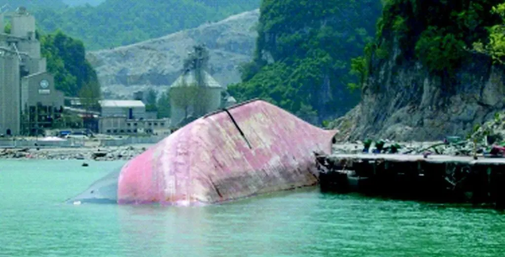 The Sinar Andalas awaits removal alongside the pier where it was left capsized by the tsunami.