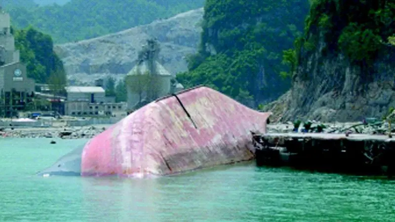 The Sinar Andalas awaits removal alongside the pier where it was left capsized by the tsunami.