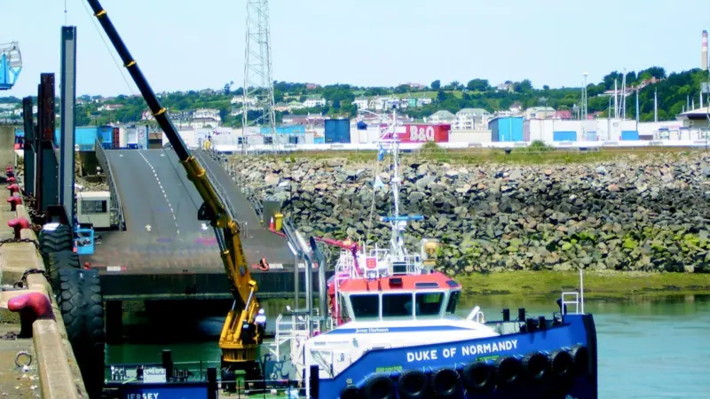Very large tides in Jersey harbour make a long reach crane invaluable.