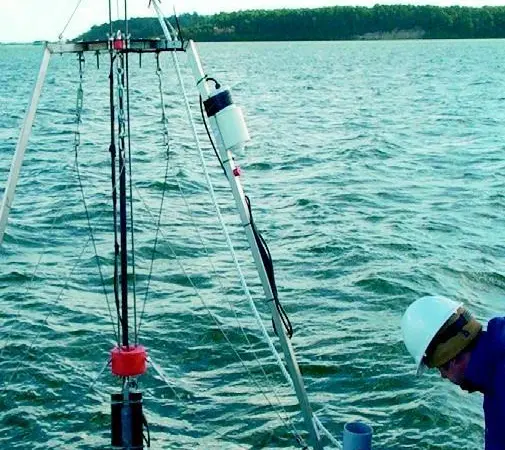 A Partrac scientist deploys dredge monitoring equipment in Poole Harbour.