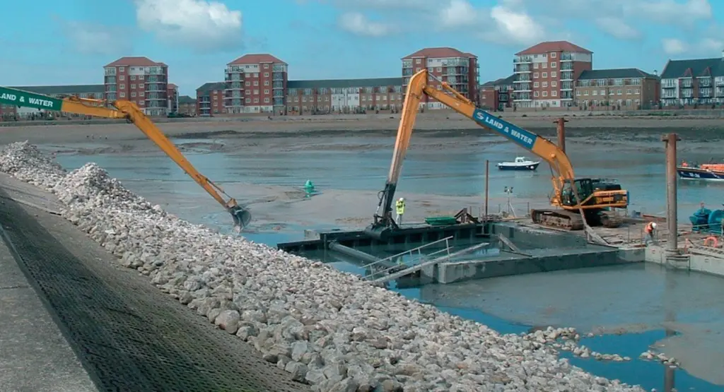two long reach excavators worked concurrently to excavate the shield and place the rock blanket at low tide.