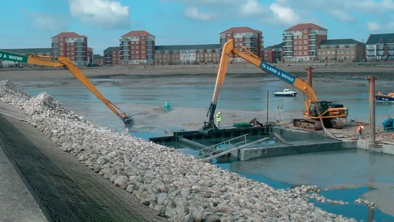 two long reach excavators worked concurrently to excavate the shield and place the rock blanket at low tide.