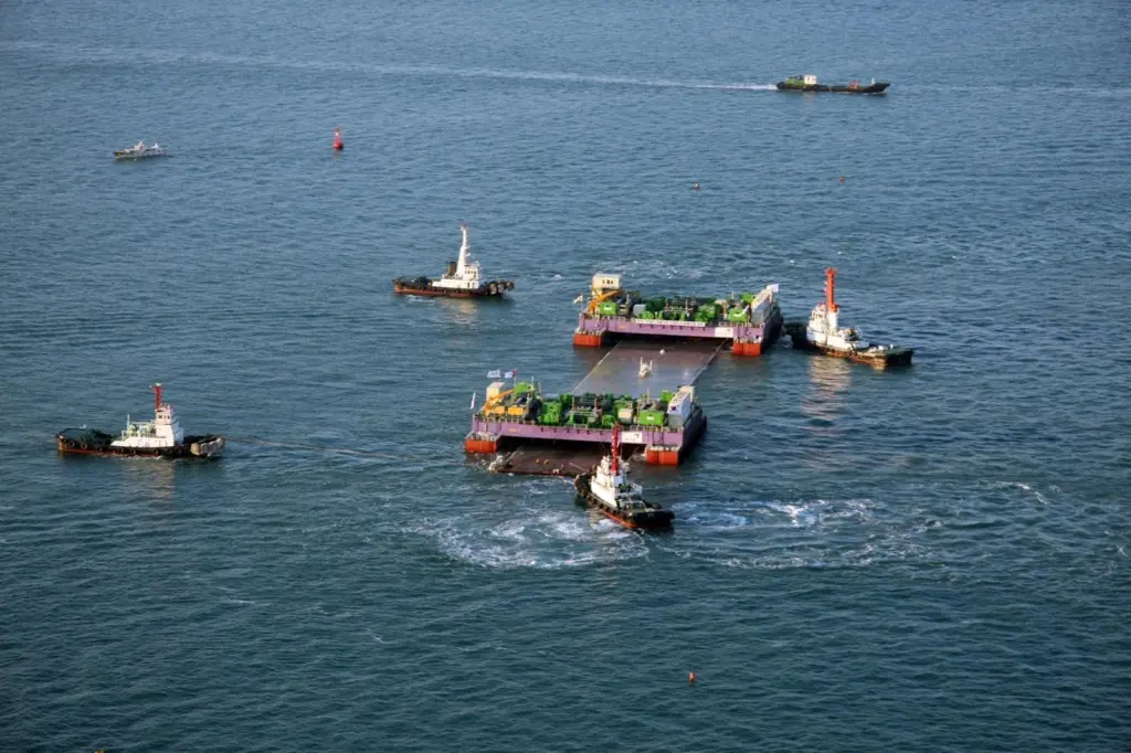 Tugs position a section of immersion tunnel at the Geoje Fixed Link works.