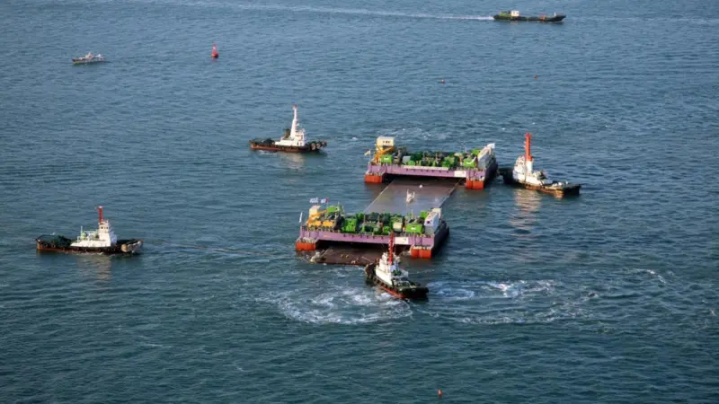 Tugs position a section of immersion tunnel at the Geoje Fixed Link works.
