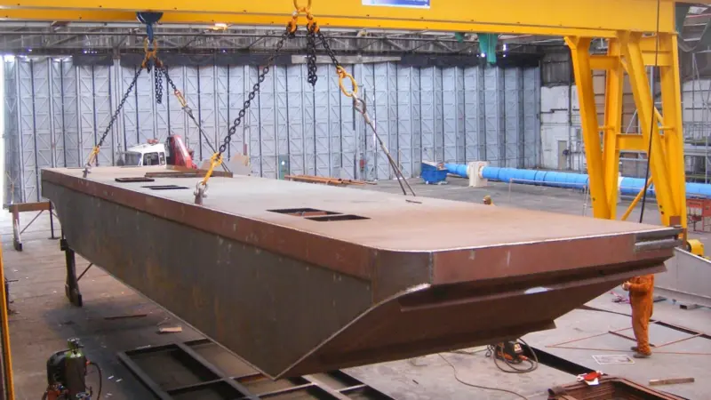 Meercat Workboats’ new gantry cranes lifting the first hull to be produced at their new Trafalgar Wharf site.