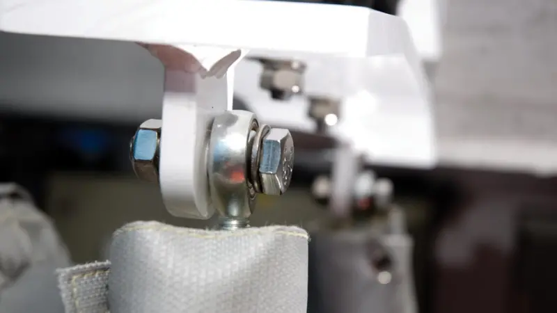 An engine mount with hexagonal bolts used as a fixing for an engine support stay, with washer and locking nut in place.