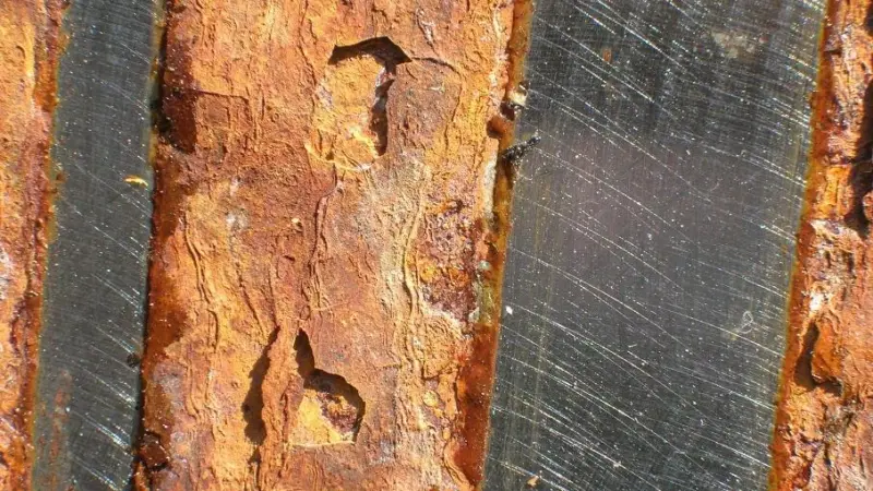 Steel plate with the un-corroded strips showing where ACW has been applied.