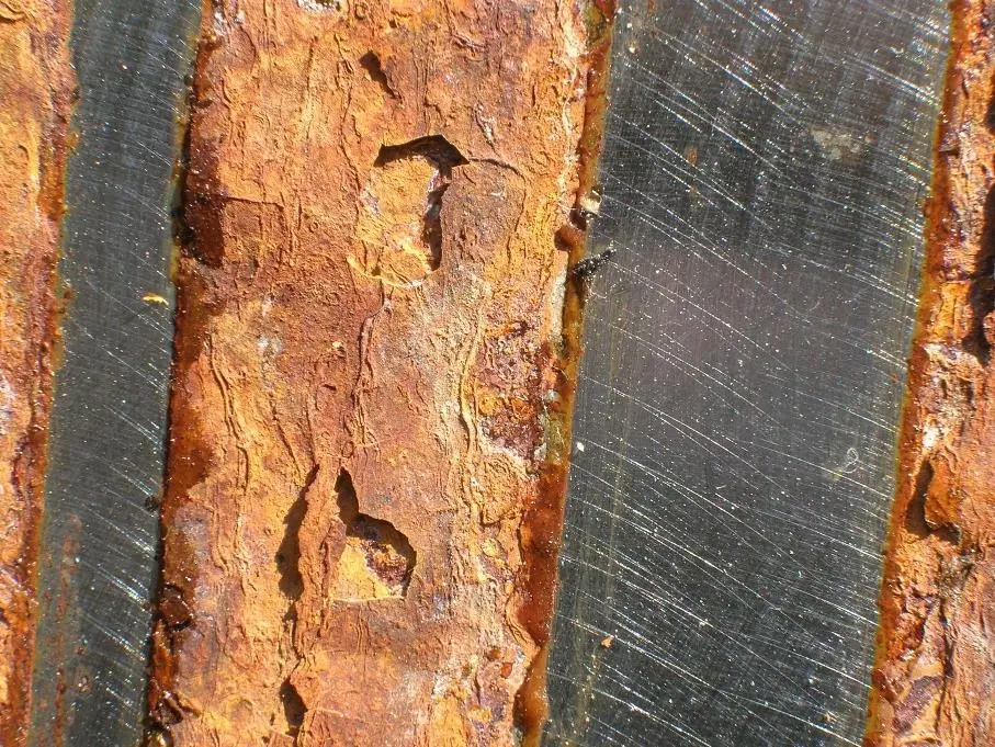 Steel plate with the un-corroded strips showing where ACW has been applied.