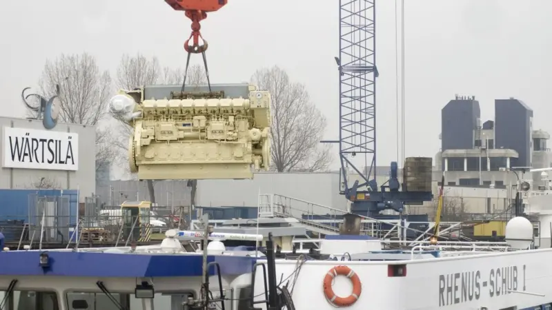 The newly remanufactured engine is lifted into position.