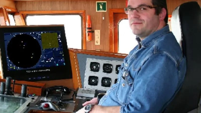 Captain Pieter den Herder in the wheelhouse of his dredger.