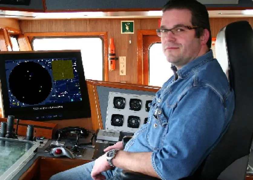Captain Pieter den Herder in the wheelhouse of his dredger.