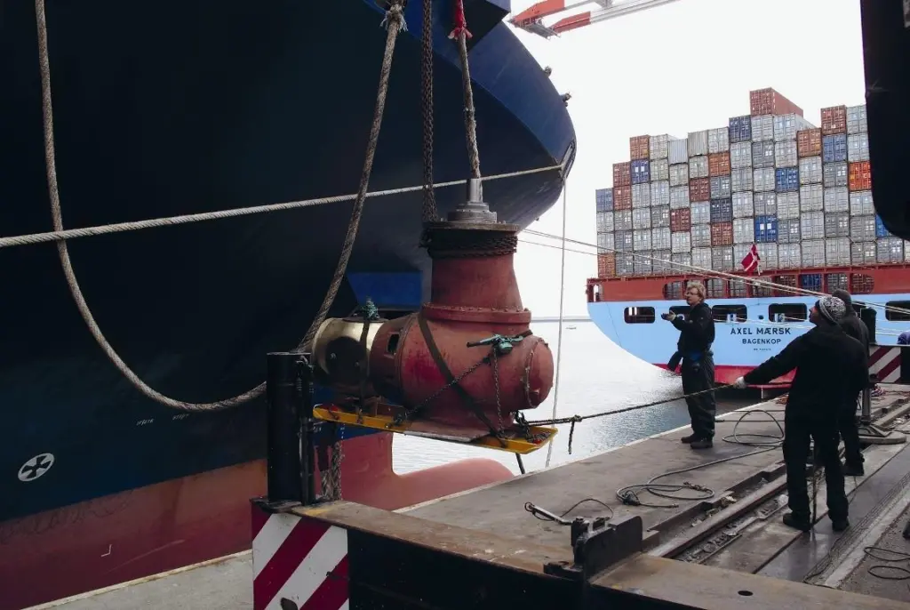 Team members are seen manoeuvring the thruster unit.