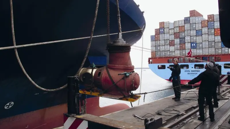 Team members are seen manoeuvring the thruster unit.