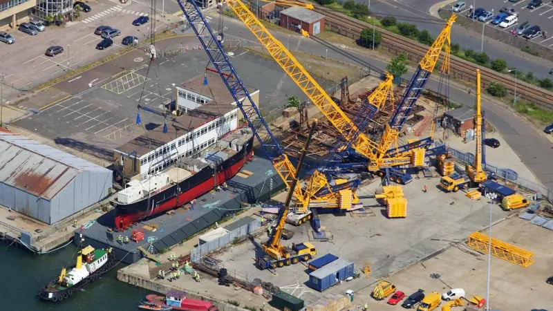 Cranes prepare to lift SS Robin, which has recently been restored in Lowestoft UK. Photo: Skyview/Mike Page