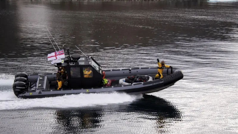 Bear Grylls waves from the bow of the RIB as it transits smooth water at more than 40 knots.