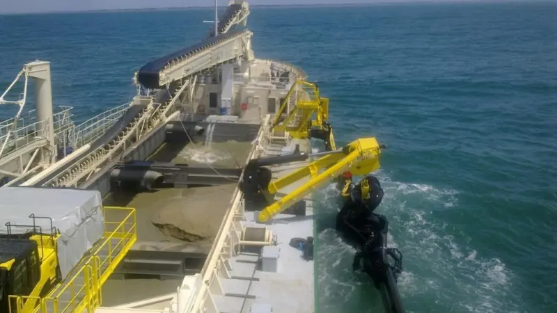 The trailing suction dredge pipe of Michel De Sousa Reis is hoisted inboard following successful sand winning.