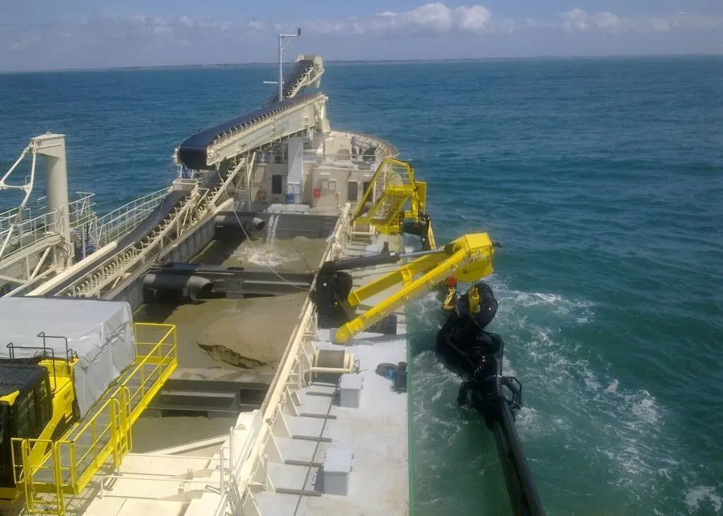 The trailing suction dredge pipe of Michel De Sousa Reis is hoisted inboard following successful sand winning.