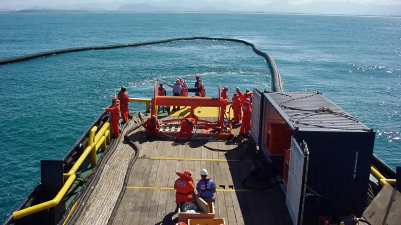 A Vikoma Weir Boom is seen both containing and recovering oil.