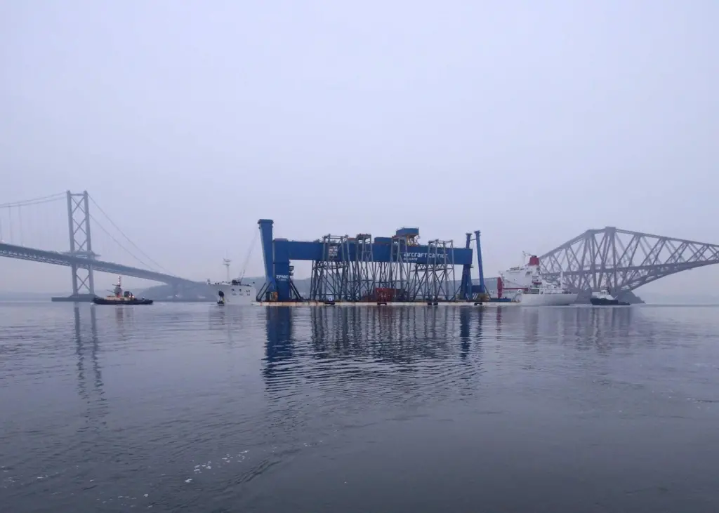 The Goliath crane is seen on its delivery vessel between the Forth road and rail bridges as it approaches the Rosyth dockyard.