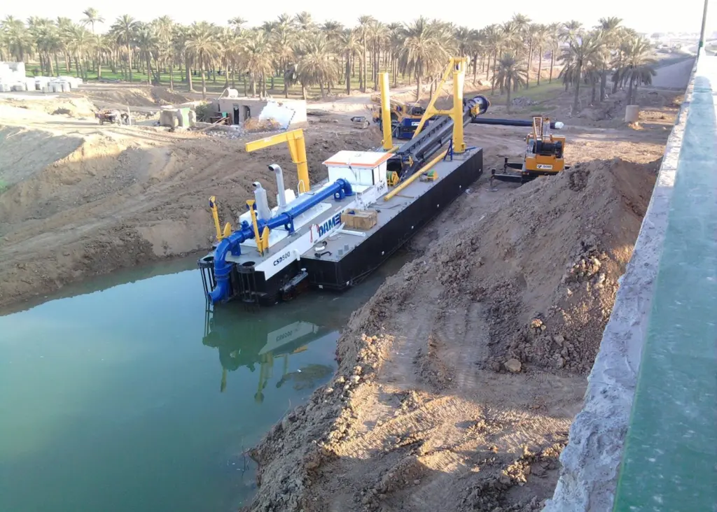 A cutter suction dredger has been assembled and is launched at a job site.