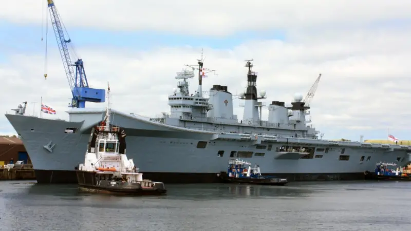 Tugs prepare to assist Illustrious as it left Rosyth for sea trials.